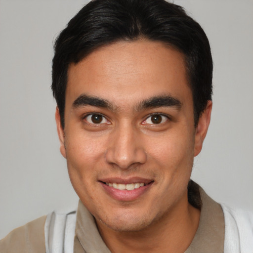 Joyful latino young-adult male with short  brown hair and brown eyes