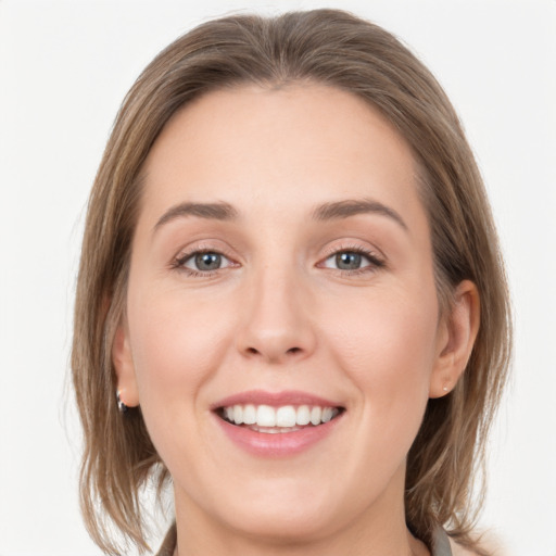 Joyful white young-adult female with medium  brown hair and grey eyes