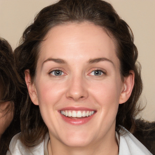 Joyful white young-adult female with medium  brown hair and blue eyes