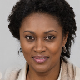 Joyful black adult female with long  brown hair and brown eyes