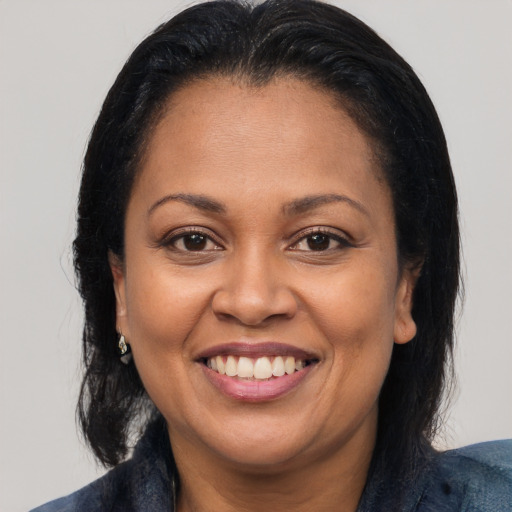 Joyful latino adult female with medium  brown hair and brown eyes