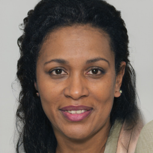 Joyful black adult female with long  brown hair and brown eyes
