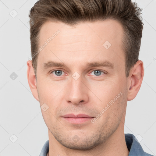 Joyful white young-adult male with short  brown hair and grey eyes