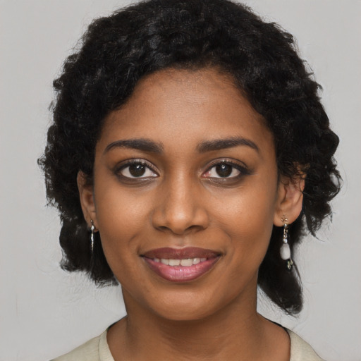 Joyful black young-adult female with long  black hair and brown eyes