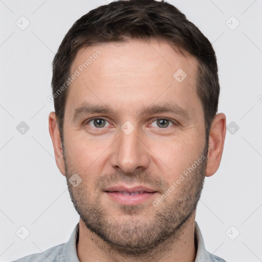 Joyful white young-adult male with short  brown hair and grey eyes