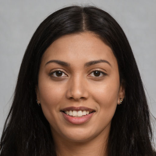 Joyful latino young-adult female with long  black hair and brown eyes