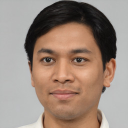 Joyful latino young-adult male with short  brown hair and brown eyes