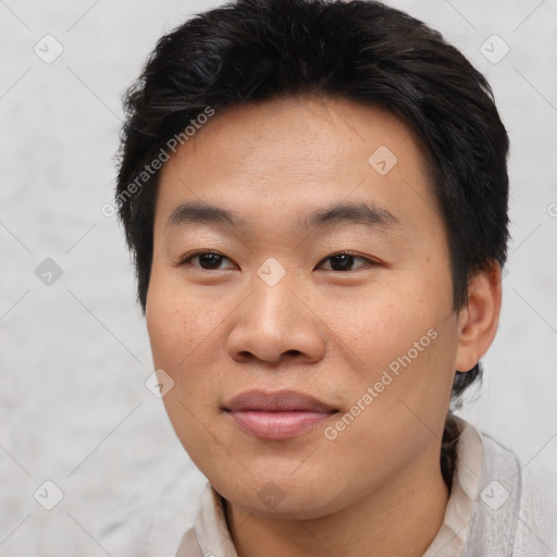 Joyful asian young-adult male with short  brown hair and brown eyes