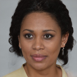 Joyful black adult female with medium  brown hair and brown eyes