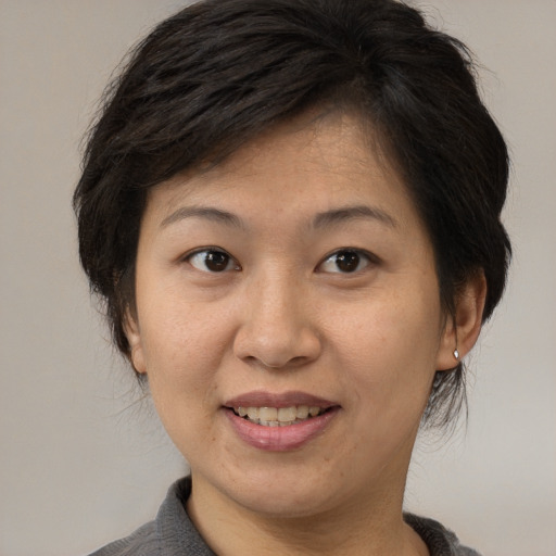 Joyful asian adult female with short  brown hair and brown eyes