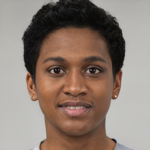 Joyful black young-adult female with short  black hair and brown eyes