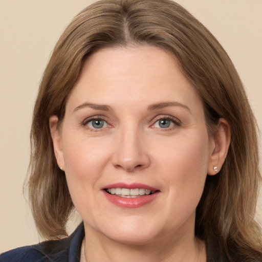 Joyful white adult female with medium  brown hair and grey eyes