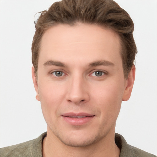 Joyful white young-adult male with short  brown hair and grey eyes