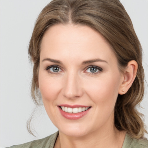 Joyful white young-adult female with medium  brown hair and grey eyes