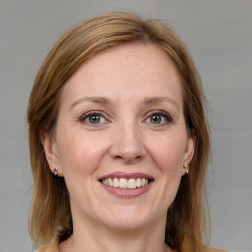 Joyful white adult female with medium  brown hair and blue eyes