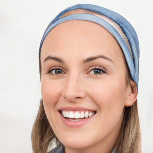 Joyful white young-adult female with long  brown hair and blue eyes