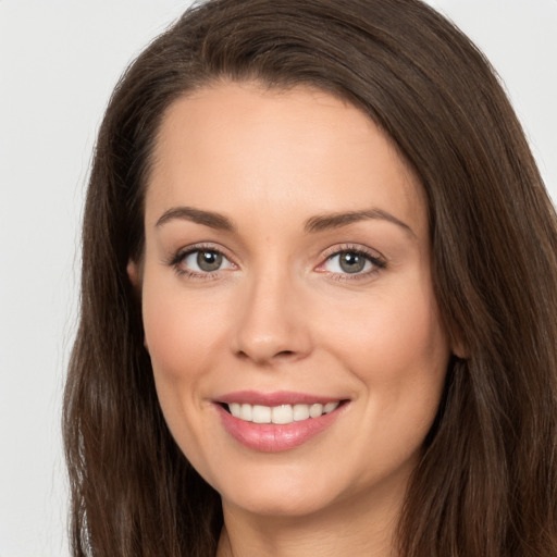 Joyful white young-adult female with long  brown hair and brown eyes