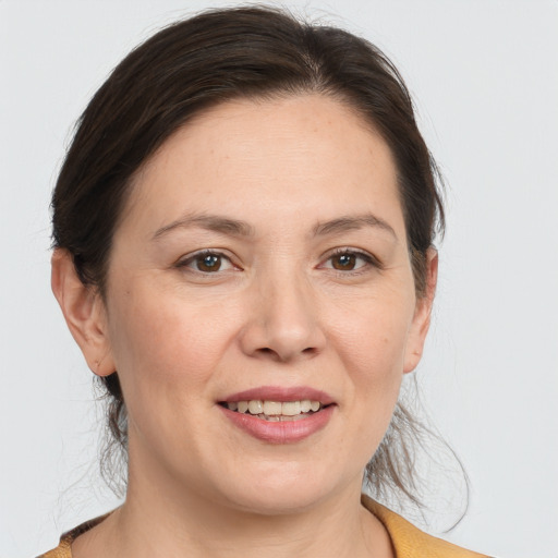 Joyful white adult female with medium  brown hair and brown eyes