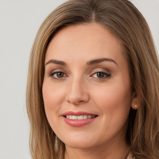 Joyful white young-adult female with long  brown hair and brown eyes