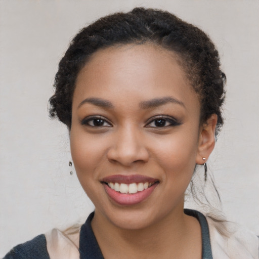 Joyful black young-adult female with long  black hair and brown eyes
