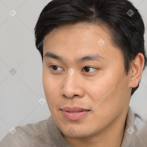 Joyful asian young-adult male with short  brown hair and brown eyes