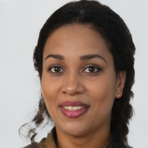 Joyful black young-adult female with long  brown hair and brown eyes