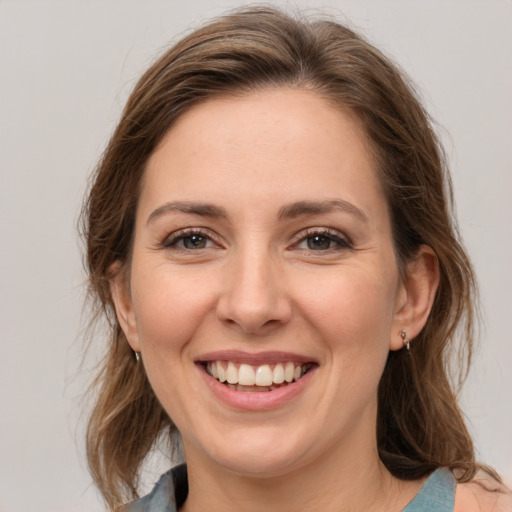 Joyful white young-adult female with medium  brown hair and grey eyes