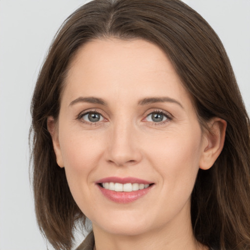 Joyful white young-adult female with long  brown hair and grey eyes