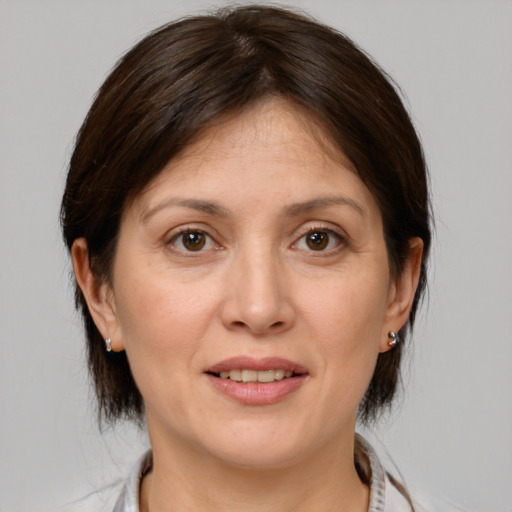 Joyful white adult female with medium  brown hair and brown eyes