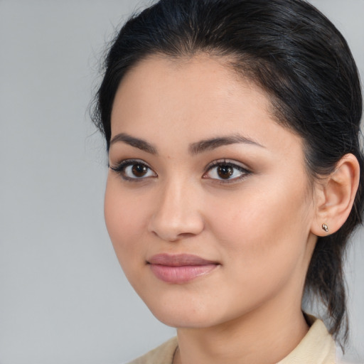 Joyful latino young-adult female with medium  brown hair and brown eyes