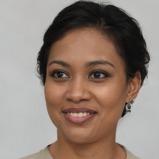 Joyful black young-adult female with medium  brown hair and brown eyes