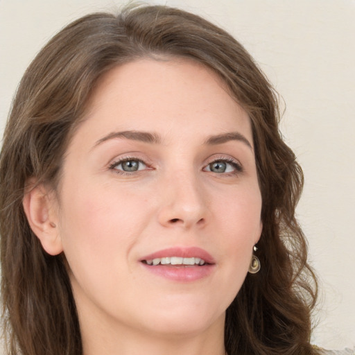 Joyful white young-adult female with long  brown hair and green eyes