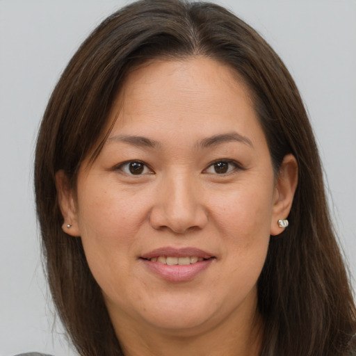 Joyful white adult female with long  brown hair and brown eyes