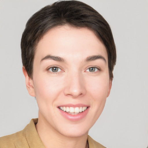 Joyful white young-adult female with short  brown hair and grey eyes