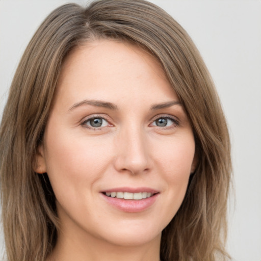 Joyful white young-adult female with long  brown hair and grey eyes