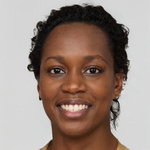 Joyful black young-adult female with long  brown hair and brown eyes