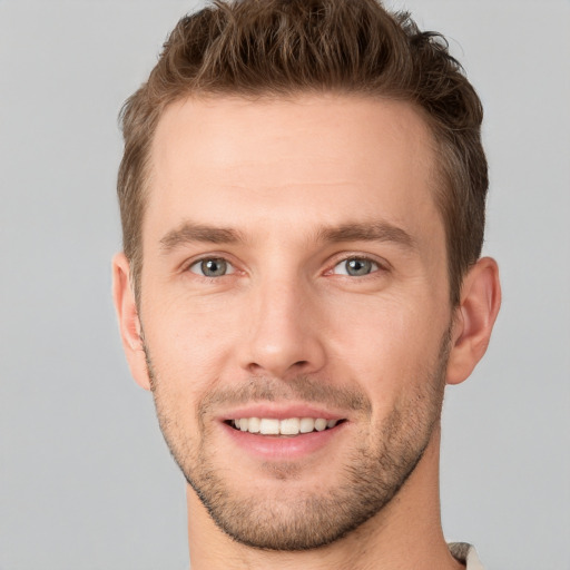 Joyful white young-adult male with short  brown hair and grey eyes