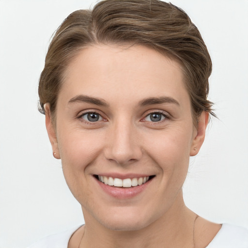 Joyful white young-adult female with short  brown hair and grey eyes