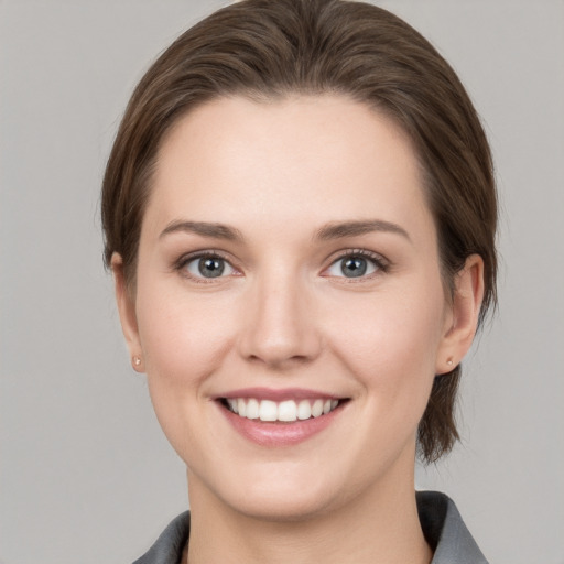 Joyful white young-adult female with medium  brown hair and grey eyes