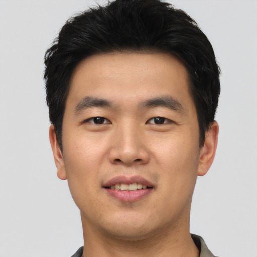 Joyful asian young-adult male with short  black hair and brown eyes