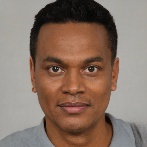 Joyful black young-adult male with short  black hair and brown eyes