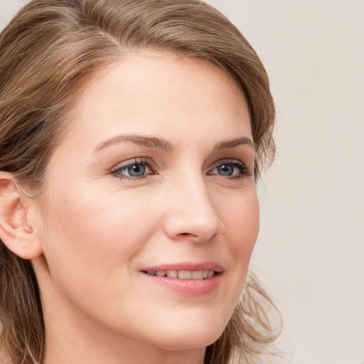 Joyful white young-adult female with long  brown hair and blue eyes