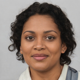 Joyful black adult female with medium  brown hair and brown eyes