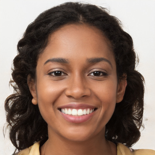 Joyful black young-adult female with long  brown hair and brown eyes