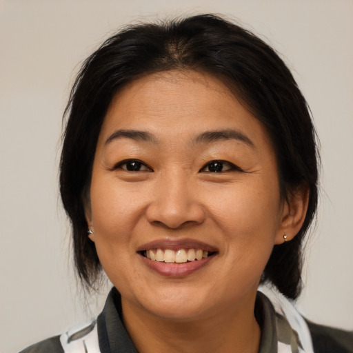 Joyful asian young-adult female with medium  brown hair and brown eyes