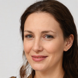 Joyful white adult female with long  brown hair and brown eyes