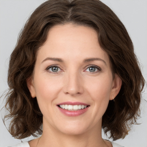 Joyful white young-adult female with medium  brown hair and green eyes