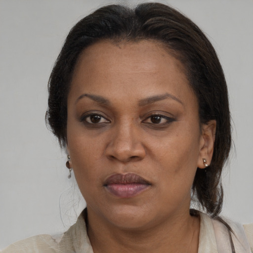 Joyful black adult female with medium  brown hair and brown eyes