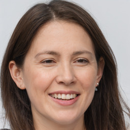 Joyful white adult female with long  brown hair and brown eyes