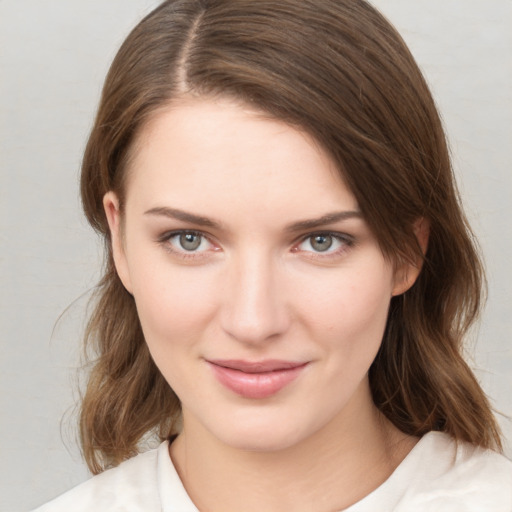 Joyful white young-adult female with medium  brown hair and green eyes